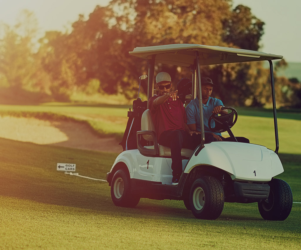 Friends riding in golf cart heading up fairway mobile